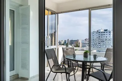 a table and chairs on a balcony with a view at Bastia - Skyline 1-BR Apt & Balcony in Nicosia in Nicosia