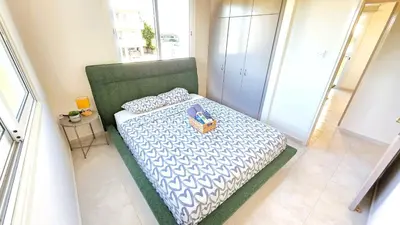 a bedroom with a bed with a purse on it at 2BR Apartment with Pool & Free Wi-Fi in Larnaka