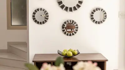 a bowl of fruit on a table with plates on the wall at EcoHarmony Villa in Paralimni
