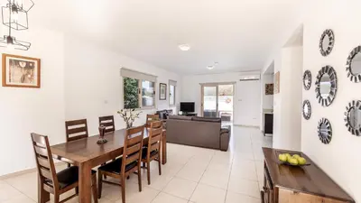 a dining room and living room with a table and chairs at EcoHarmony Villa in Paralimni