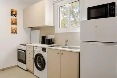 a white kitchen with a sink and a refrigerator at Urban Bay Studios in Limassol