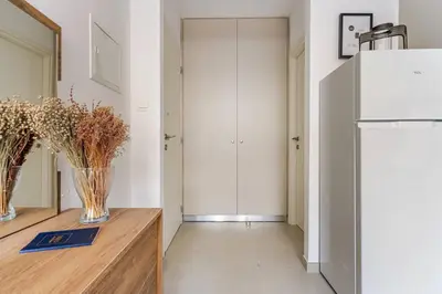 a kitchen with a refrigerator and vases on a wooden table at Urban Bay Studios in Limassol