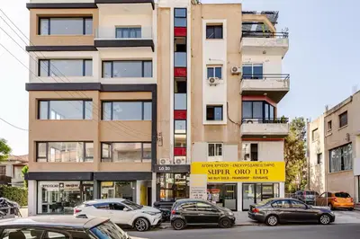 a tall building with cars parked in a parking lot at Urban Bay Studios in Limassol