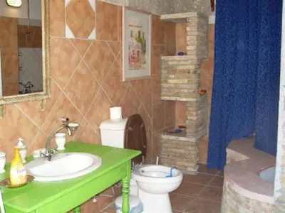 a bathroom with a green sink and a toilet at Historic 600 years old beautifully renovated Mill House in Meniko