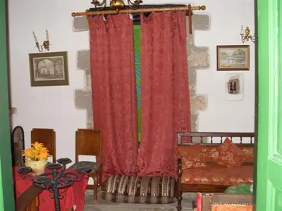 a living room with a red curtain and a table at Historic 600 years old beautifully renovated Mill House in Meniko