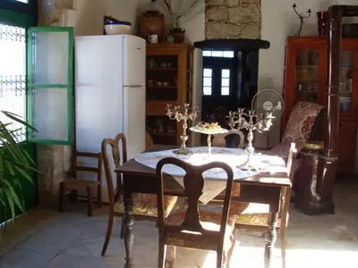 a dining room table with chairs and a white refrigerator at Historic 600 years old beautifully renovated Mill House in Meniko