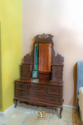 a wooden dresser in a room with a mirror at The Historical Cypriot House, Beautifully Renovated Traditional Stone House in Ayios Ioannis