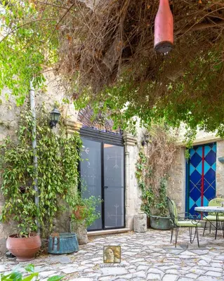 a patio with a table and chairs in front of a building at The Historical Cypriot House, Beautifully Renovated Traditional Stone House in Ayios Ioannis
