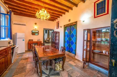 a kitchen with a wooden table in a room at The Historical Cypriot House, Beautifully Renovated Traditional Stone House in Ayios Ioannis