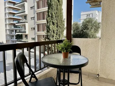 a small table and chairs on a balcony at STAY McKenzie Mile in Larnaka