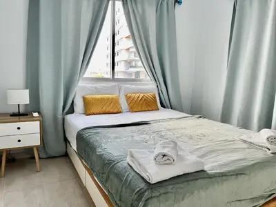 a bed with towels on it in a room with a window at STAY McKenzie Mile in Larnaka