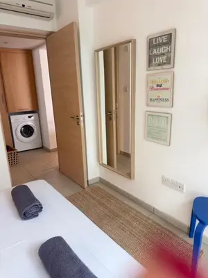 a room with a bed and a mirror and a door at A Home at Coralli - Protaras Beach Apartment, 30 m from beach in Protaras