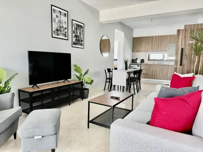 a living room with a couch and a flat screen tv at Bright & cozy apartment in Livadia in Livadhia