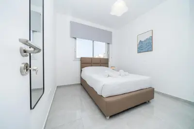 a white bedroom with a bed and a mirror at New 2 bedroom flat in Aglantzia in Aglantzia