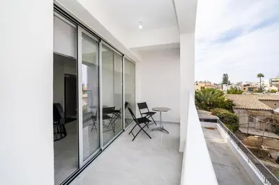 a balcony with glass walls and a table on a roof at New 2 bedroom flat in Aglantzia in Aglantzia
