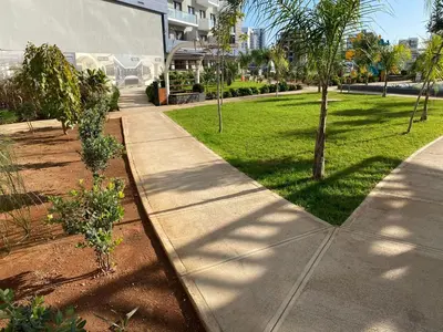 a sidewalk in front of a building with trees at Rıversıdelıfe Iskele 164 in Vuda