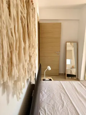 a bedroom with a bed and a mirror at Rope and Reef 2BD Walk to Nissi Beach and Pool in Ayia Napa