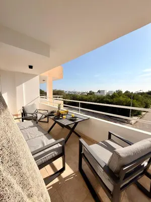 a balcony with furniture and a view of a city at Rope and Reef 2BD Walk to Nissi Beach and Pool in Ayia Napa