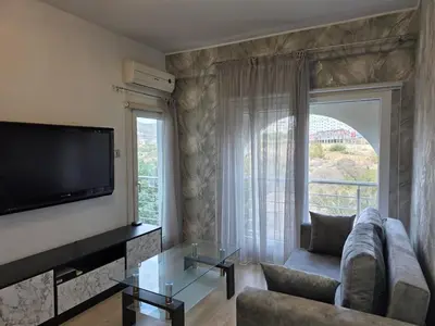 a living room with a couch and a large window at White Arches Haven by Staycom in Limassol