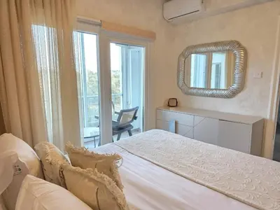 a bedroom with a white bed and a mirror at White Arches Haven by Staycom in Limassol