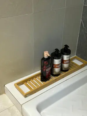 a shelf above a bath tub with three bottles on it at Blue Edge Makenzy in Larnaka