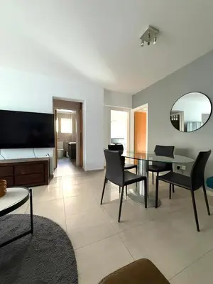 a living room with a table and chairs and a mirror at Blue Edge Makenzy in Larnaka