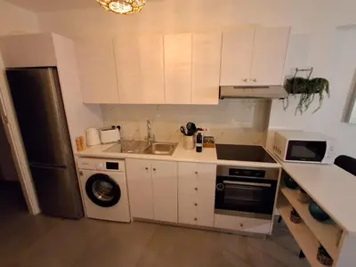 a kitchen with white cabinets and a black refrigerator at Lazuli City Center Ap 11 in Larnaka
