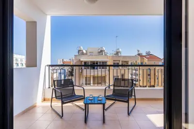 two chairs and a table on a balcony at Averna - Breezy 2-BR Apt & Balcony in Larnaca in Larnaka