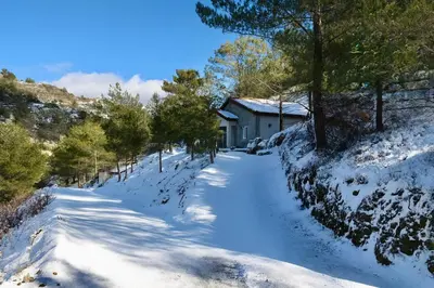 a snow covered road leading to a house at Gazingstars Cottages Agridia