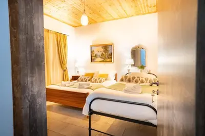 a bedroom with two beds and a mirror at Gazingstars Cottages Agridia