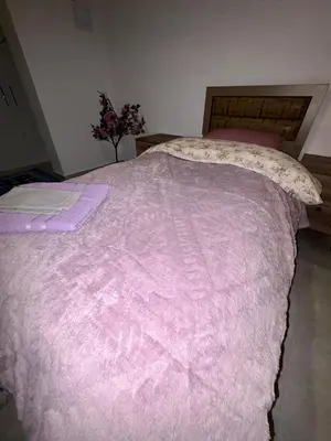 a bed with a pink comforter in a bedroom at Lapta Purple 2 bedroom in Peristerona