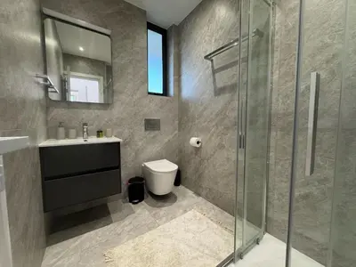 a bathroom with a toilet and a glass shower at Sunrise Pearl - 2 min walk to Sirena Bay in Paralimni