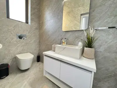 a bathroom with a white sink and a toilet at Sunrise Pearl - 2 min walk to Sirena Bay in Paralimni