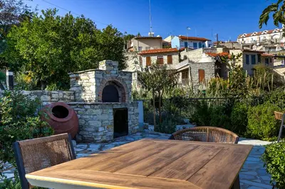 a wooden table and chairs with a stone fireplace at Horizon View Lefkara with Pool, Garden, Parking in Pano Lefkara
