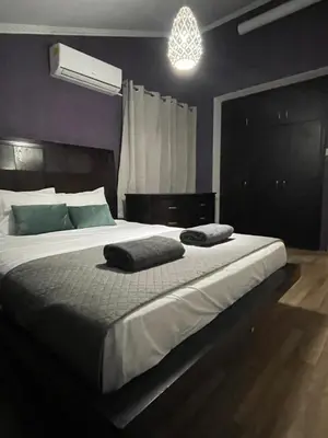 a bedroom with a large bed with two towels on it at Serenity Home - Holiday Apt Larnaca in Larnaka