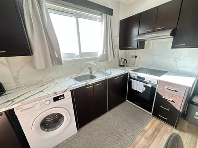 a kitchen with a washing machine and a sink at Serenity Home - Holiday Apt Larnaca in Larnaka