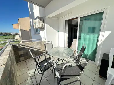 a balcony with a glass table and chairs at Serenity Home - Holiday Apt Larnaca in Larnaka