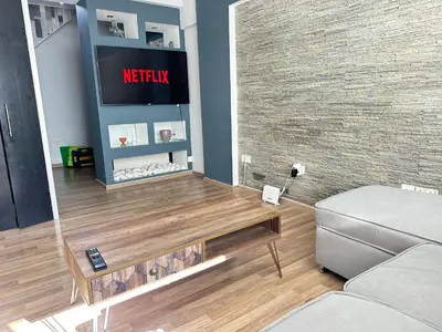 a living room with a tv and a couch at Serenity Home - Holiday Apt Larnaca in Larnaka