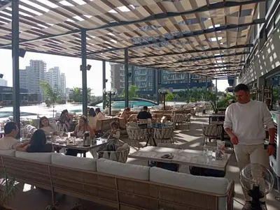 a man standing in a restaurant with people sitting at tables at Studıo Iskele 150 in Aglantzia