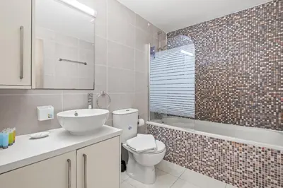 a bathroom with a toilet and a sink and a tub at Downtown 2 Bedroom City Flat in Larnaka