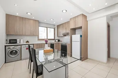 a kitchen with a glass table and a dishwasher at Downtown 2 Bedroom City Flat in Larnaka