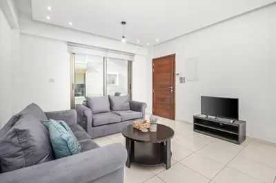 a living room with a couch and a tv at Downtown 2 Bedroom City Flat in Larnaka