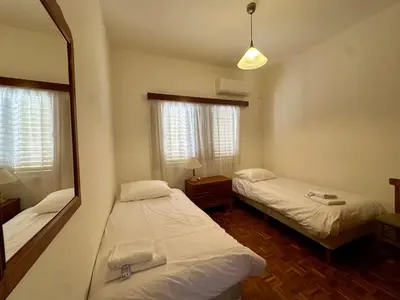 a room with two beds and a mirror at 2 bedroom flat by the sea in Larnaka