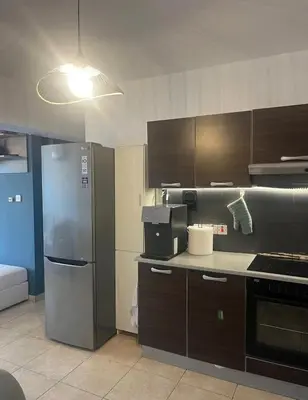 a kitchen with a stainless steel refrigerator and cabinets at 2 bedroom flat in centre in Larnaka