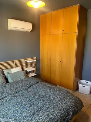a bedroom with a bed and a wooden cabinet at 2 bedroom flat in centre in Larnaka