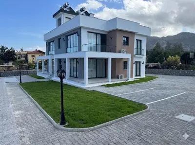 a large white house with a parking lot at Soğular Apartments 1 in Aglantzia