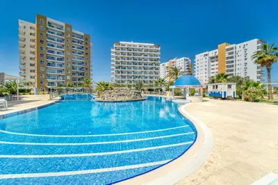 a large swimming pool with buildings in the background at Hotel apartment studio in Dherinia