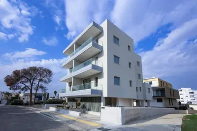 a white building with blue balconies on a street at Chrystal Residences in Nicosia