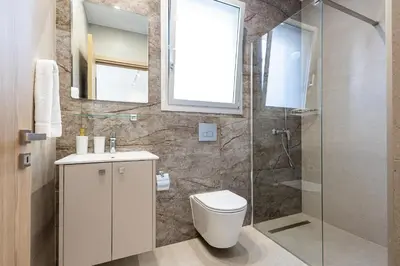a bathroom with a toilet and a glass shower at Chrystal Residences in Nicosia