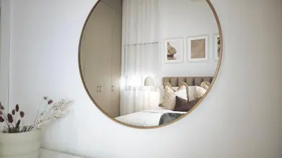 a mirror on a wall in a bedroom with a bed at City and Sea 12 in Larnaka